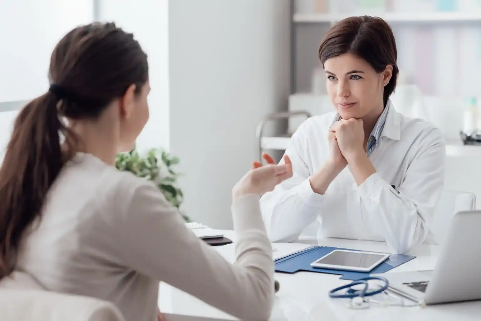 A psychologist listens attentively to a patient during a therapy session.